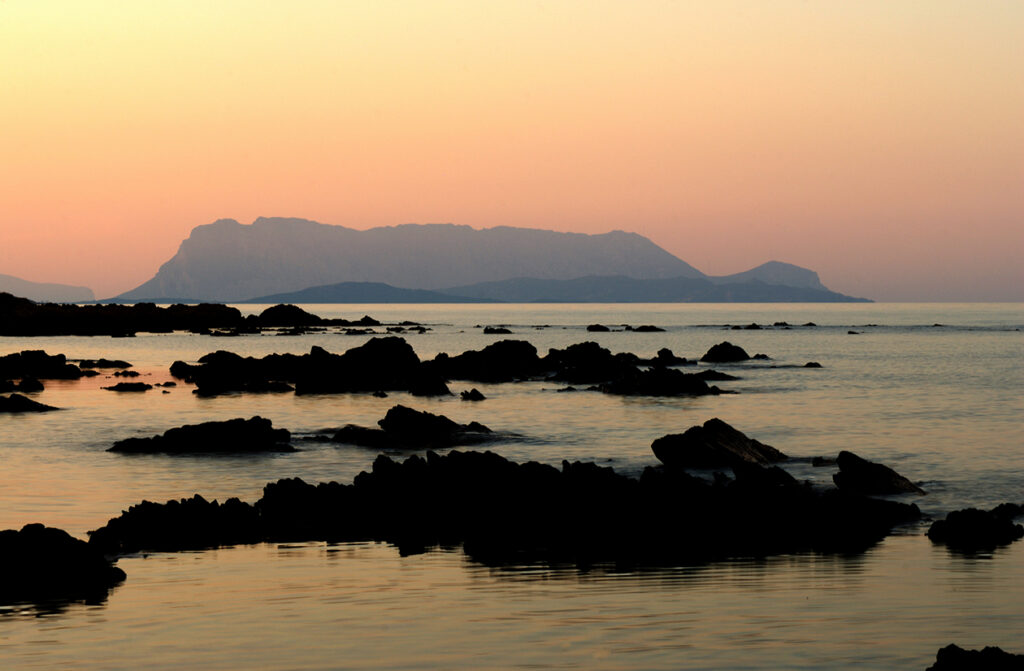 Veduta dell' isola di Tavolara dalla costa a sud di Tanaunella al tramonto.